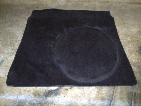 2002 Ford Mustang - This black trunk mat features a circular indentation and a SuperMotors logo at the bottom right corner.