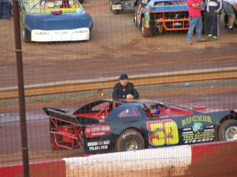 1979 Ford F-150 - A dirt track race car with sponsor decals and a driver in the cockpit sits on the track.