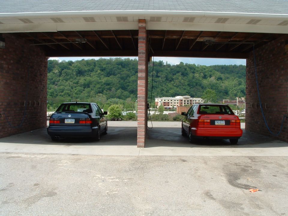1994 Volkswagen Jetta, dark blue, parked under a carport next to a red Jetta