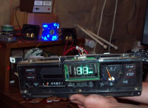 1985 Ford Crown Victoria LTD - Instrument cluster with digital speedometer and analog fuel gauge is held by a hand.
