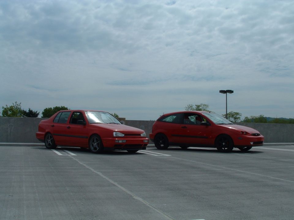 Red 1994 Volkswagen Jetta and a red hatchback parked side-by-side