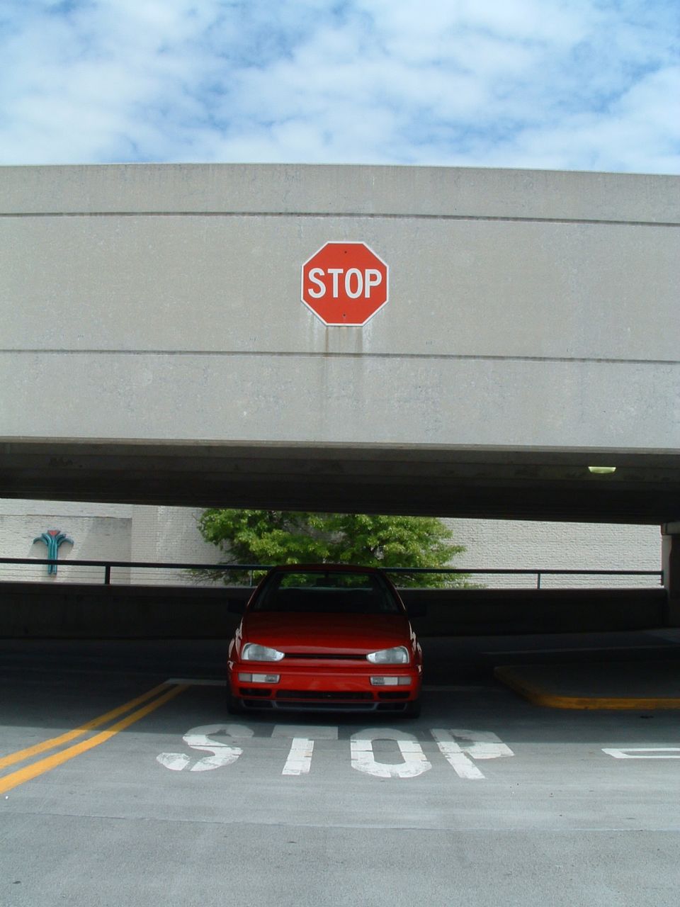 Red 1994 Volkswagen Jetta parked in a garage with a stop sign above