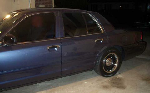 1998 Ford Crown Victoria - Side profile of a blue 1998 Ford Crown Victoria sedan with tinted windows and chrome accents.