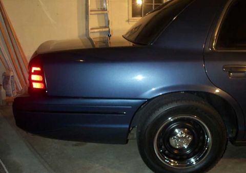 1998 Ford Crown Victoria - Rear view of a blue 1998 Ford Crown Victoria showing the tail light and wheel.