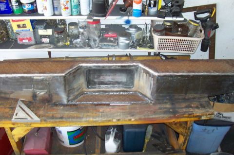 1994 Ford F-150 - A fabricated metal bumper sits on a workbench, surrounded by various tools and storage containers.