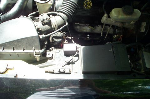 1999 Ford Crown Victoria - Engine compartment of a 1999 Ford Crown Victoria, showing the air intake system and brake fluid reservoir.