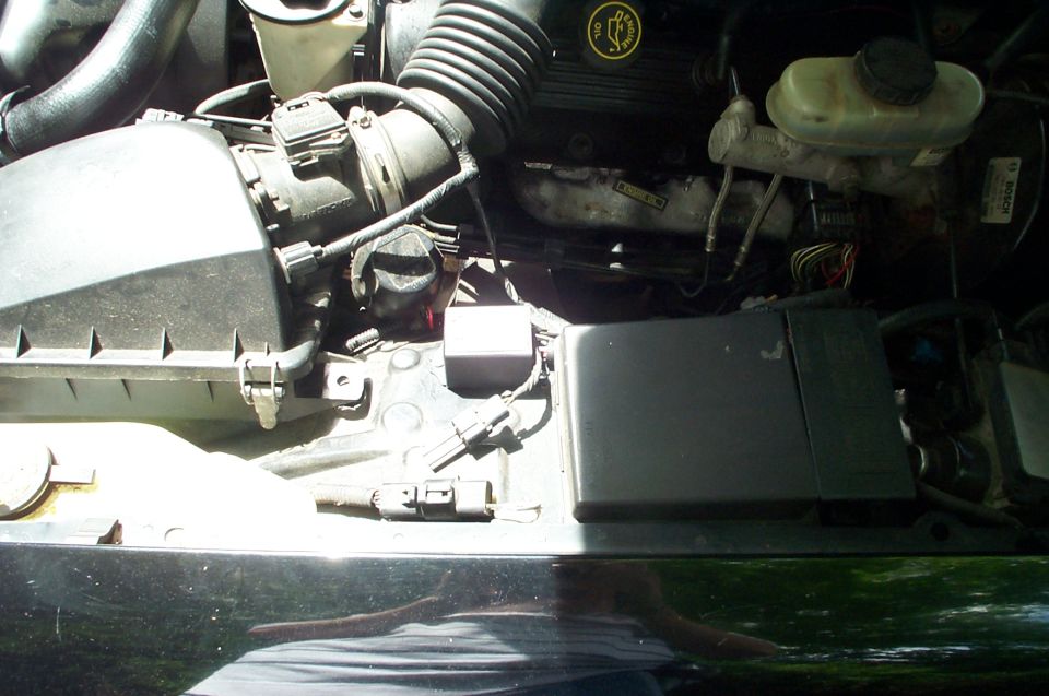 Engine bay showing airbox, intake tube, brake master cylinder reservoir and fuse box