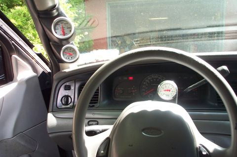 1999 Ford Crown Victoria - Aftermarket gauges are installed on the A-pillar and steering column of this Ford Crown Victoria.