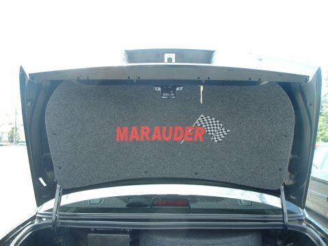 1999 Ford Crown Victoria - The trunk lid's interior panel displays 'Marauder' text and a checkered flag emblem.