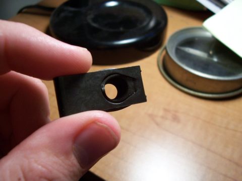 1995 Ford Bronco - Close-up of a metal clip being held by fingers, with other objects blurred in the background.