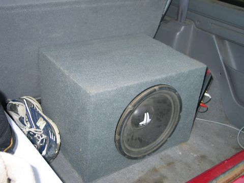 1995 Ford Bronco - A subwoofer box and a shoe are visible in the rear cargo area of a vehicle.