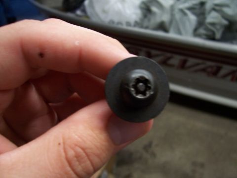 1995 Ford Bronco - A hand holds a Torx screw, likely a component for a hard top clip, with a blurred background.