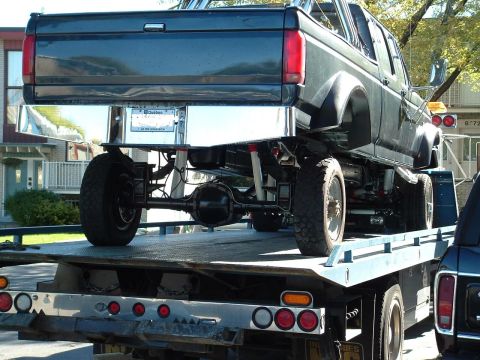 1979 Ford Bronco - A dark blue 1992 Ford F-350 Crew Cab truck is loaded onto a flatbed tow truck.
