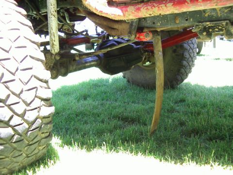 1985 Ford Bronco - Close-up view of the suspension and tire of a modified off-road vehicle.
