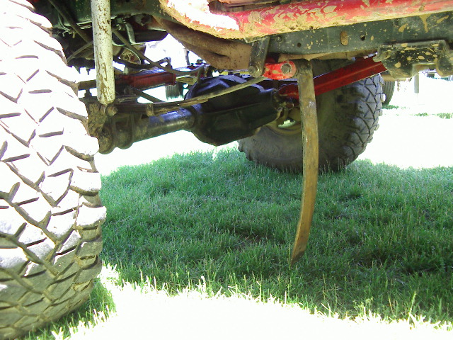 Off-road vehicle's large tire, suspension components, and differential visible