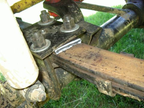 1985 Ford Bronco - Detail of vehicle suspension shows a rusty leaf spring and its attachment hardware.