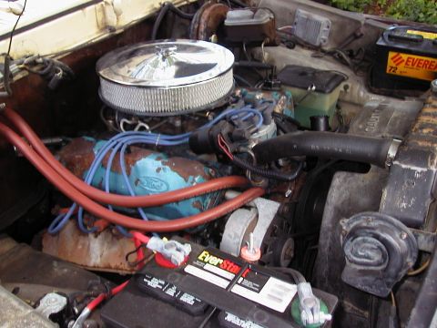 1979 Ford Bronco - Engine bay of a 1979 Ford Bronco, a V8 engine with aftermarket air cleaner and dual batteries.