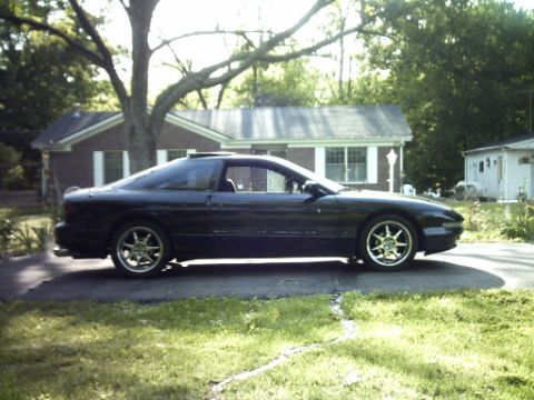 1995 Ford Probe - A black 1995 Ford Probe is parked in a suburban driveway on a sunny day.