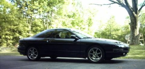 1995 Ford Probe - A black 1995 Ford Probe coupe is shown from the side with a front quarter view.