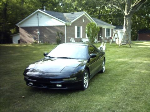 1995 Ford Probe - A black 1995 Ford Probe sits on a green lawn in front of a suburban house.