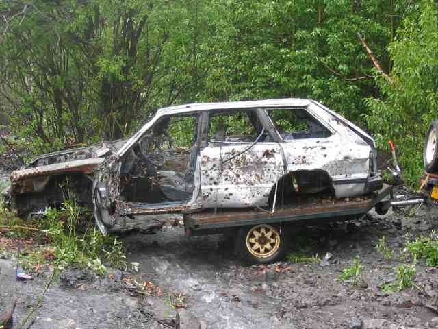 wrecked car on a trailer, looks like it's been burned