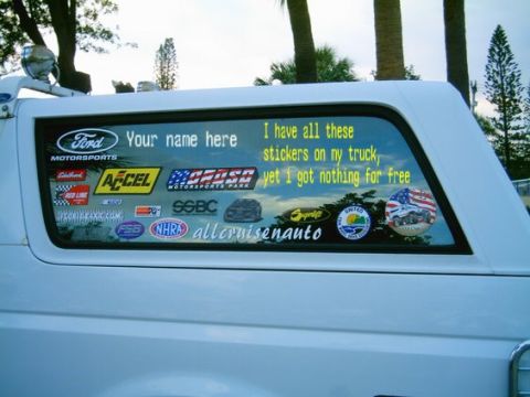 1993 Ford Bronco - Rear window of a 1993 Ford Bronco displays numerous stickers and custom text.