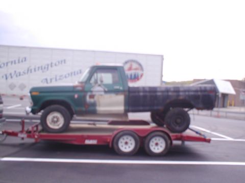 1979 Ford Bronco - A Ford F-Series pickup truck is being transported on a red trailer.