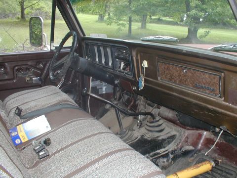 1979 Ford Bronco - The interior of this truck features a wood-grain trim panel on the dashboard and a patterned fabric seat.