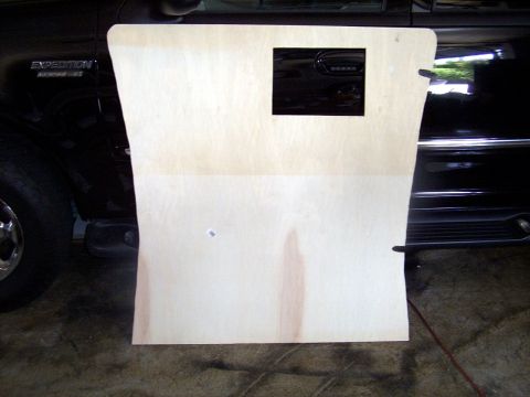 1978 Ford Mustang II - A custom-cut wooden panel is positioned in front of a black Ford Expedition's door.