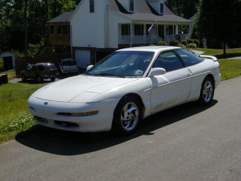 1994 Ford Probe - A white 1994 Ford Probe GT is parked in front of a house, with two other vehicles visible in the background.