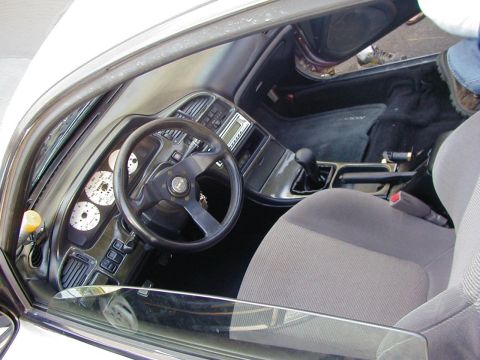 1994 Ford Probe - Interior view of a car's dashboard, steering wheel, and seats, showing aftermarket modifications.