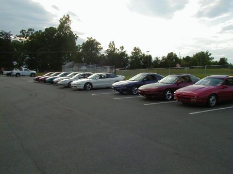1994 Ford Probe - A row of Ford Probes from the mid-1990s are parked in a lot under a cloudy sky.