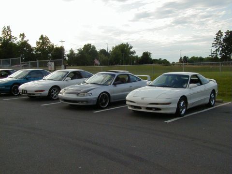 1994 Ford Probe - A row of cars are parked in an outdoor lot under a cloudy sky.