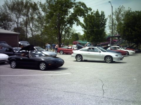 1995 Ford Probe - A variety of cars are parked in an outdoor lot on a cloudy day.