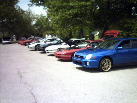 1995 Ford Probe - A line of cars are parked outdoors, with a blue Subaru WRX prominently featured in the foreground.