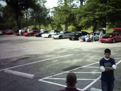 1995 Ford Probe - A group of Ford Probe cars are gathered in a parking lot on a sunny day.