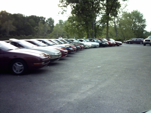 Maroon 1995 Ford Probe in a line of cars, front 3/4 view, parked on asphalt
