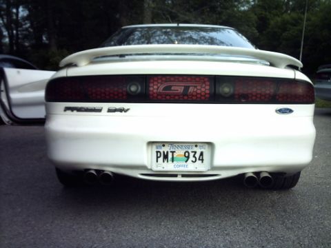 1995 Ford Probe - Rear view of a white 1995 Ford Probe GT, a prominent spoiler and dual exhaust pipes. The vehicle has a Tennessee license plate.