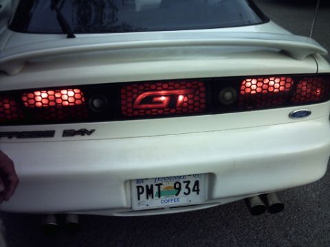 1995 Ford Probe - Rear view of a white car, showing custom taillights and a spoiler. The license plate is from Tennessee.