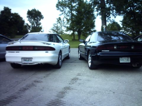 1995 Ford Probe - Rear view of two Ford Probe cars, a white one and a black one, parked outdoors.
