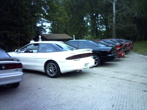 Several Ford Probes parked in a row, white one in foreground