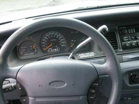 2001 Ford Crown Victoria - Interior view of a Ford Crown Victoria, showing the steering wheel, dashboard, and instrument cluster with mileage displayed.