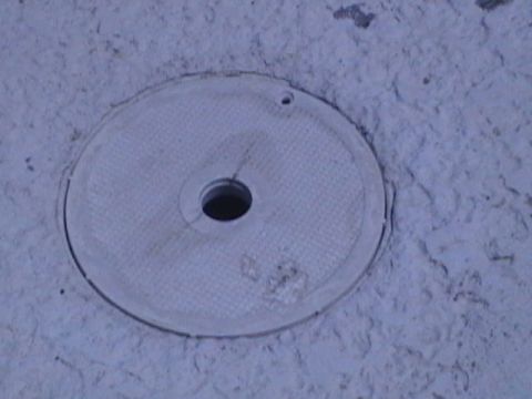 1994 Ford Bronco - A round metal cover with a hole in the center is shown in this close-up view.