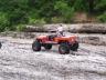 1985 Toyota 4Runner - An orange remote-controlled off-road vehicle navigates a rocky terrain.