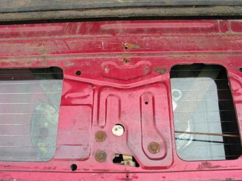 1995 Ford Bronco - Close-up of a red tailgate's interior, revealing the latch assembly and window frame.