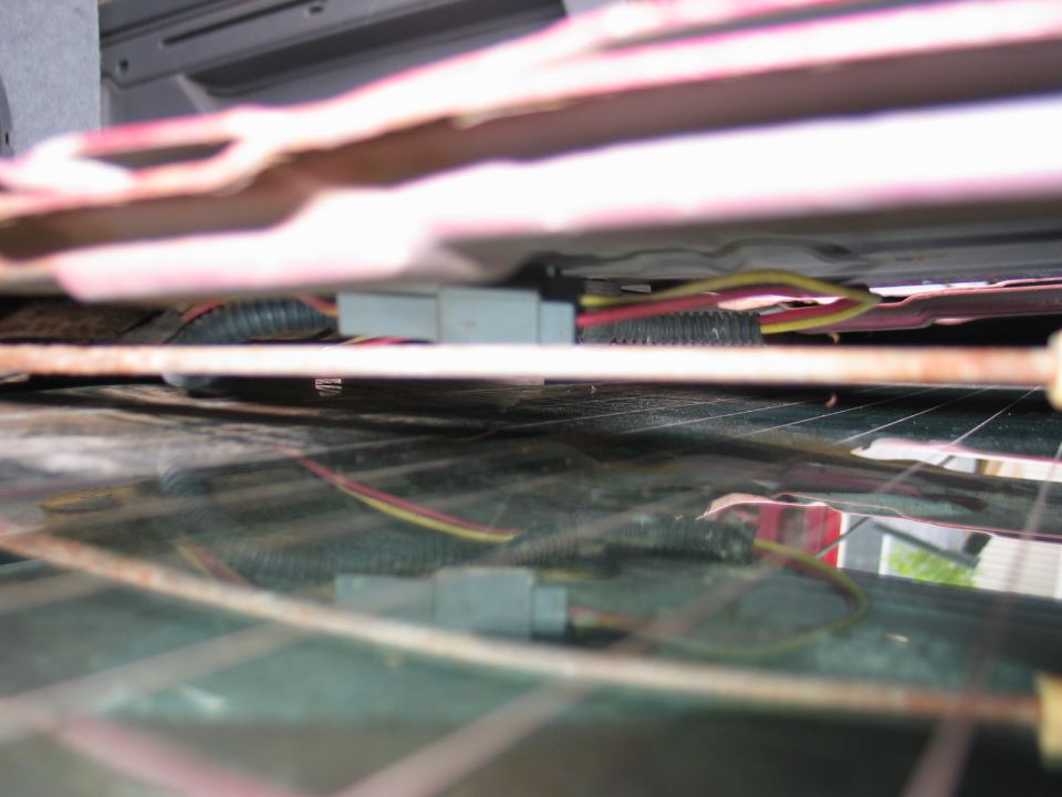 Wiring harness and gray connector above a rear defroster window glass edge
