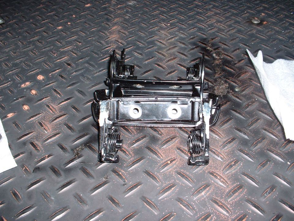 black metal car part with springs and mounting holes