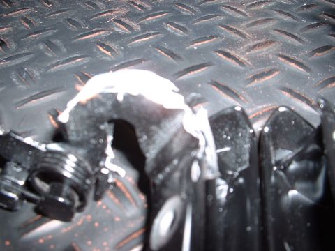 1978 Ford Mustang II - A close-up view of an unidentified automotive part with white residue, set against a textured metal background.