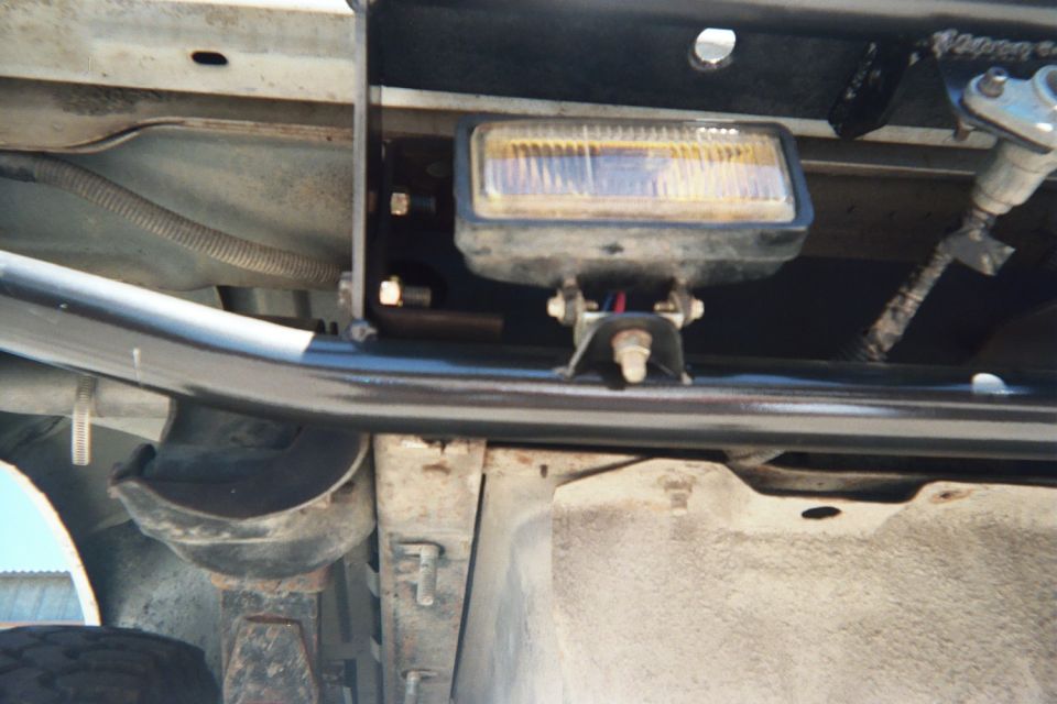 Underside view of a mounted rectangular driving light and tube bumper