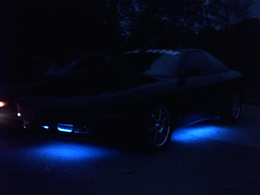 Dark Ford Probe coupe at night with blue neon underglow under the front and side